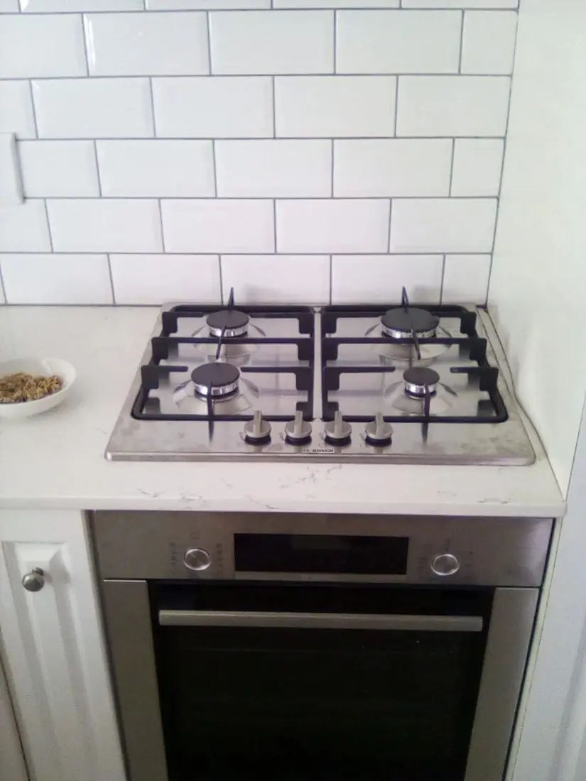 A four-burner stainless steel gas hob above a built-in oven
