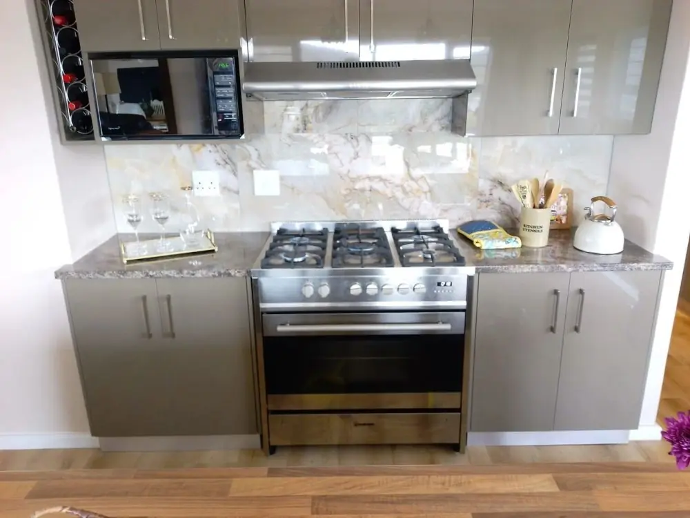 A freestanding stainless steel gas stove installed in a modern kitchen